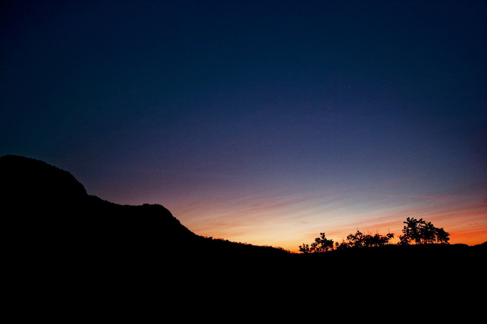 Crepúsculo laranja passando a azul sobre a serra