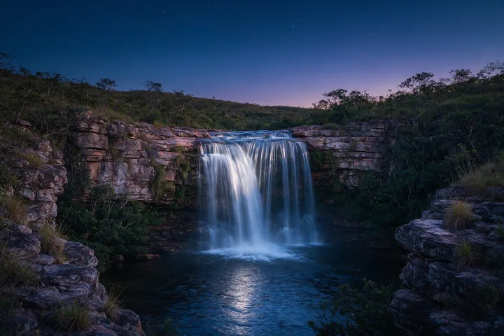 Cachoeira entre rochas de quartzito ao anoitecer na Chapada dos Veadeiros